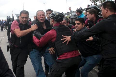 Policía intenta evacuar a Sergio Berni, ministro de Seguridad de la provincia de Buenos Aires, atacado por manifestantes.