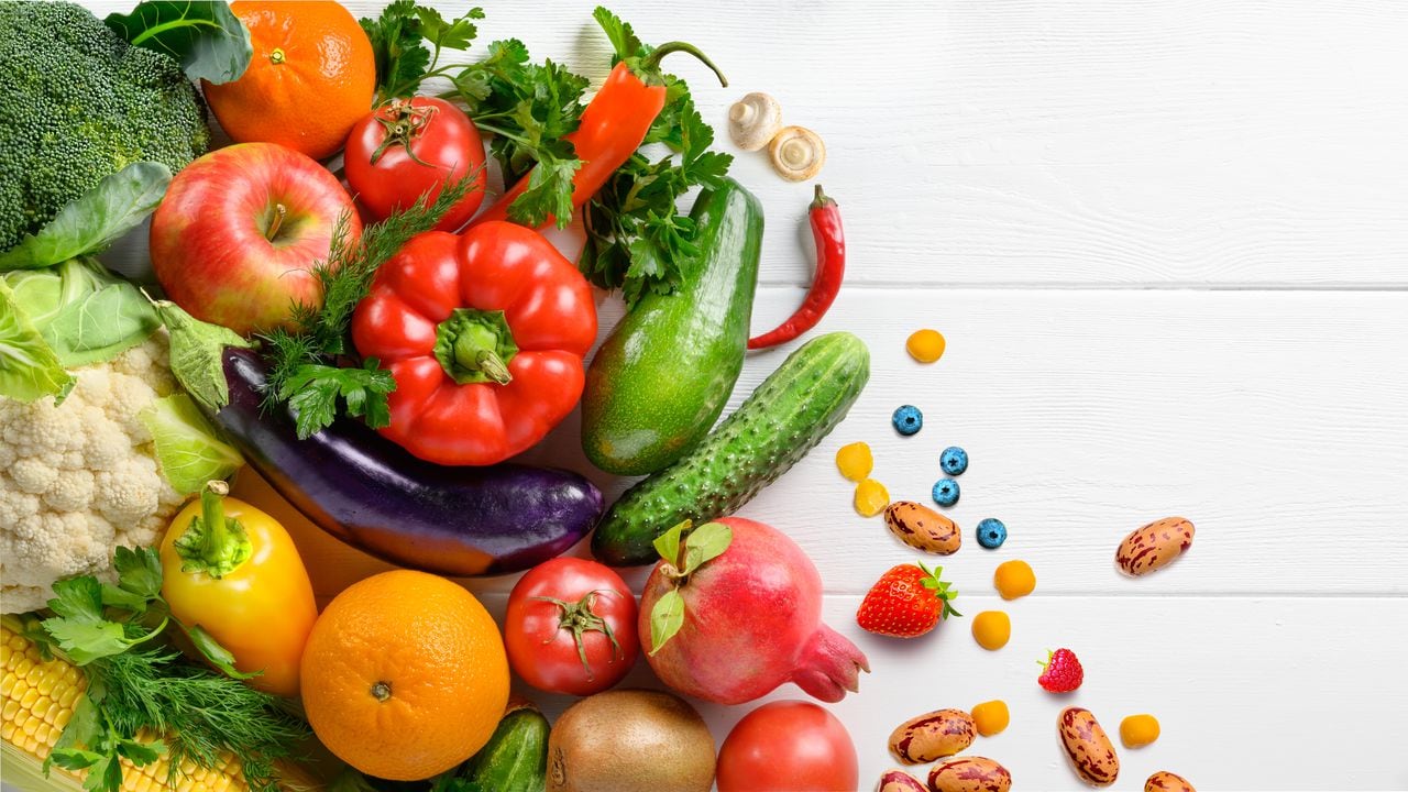 Fondo de alimentos orgánicos saludables. Fotografía de alimentos diferentes frutas y verduras sobre fondo de mesa de madera blanca. Vista superior