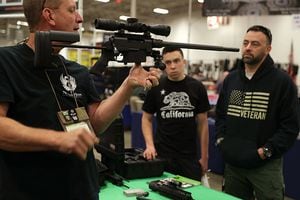 CHANTILLY, VA - NOVEMBER 18:  A gun seller demonstrates a firearm to potential buyers during the Nation's Gun Show on November 18, 2016 at Dulles Expo Center in Chantilly, Virginia. The show is one of the largest in the area.  (Photo by Alex Wong/Getty Images)