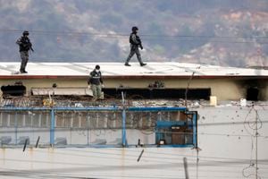 El cuerpo de un preso es rodeado por policías en el techo de la Penitenciaría del Litoral la mañana después de que estallaran los disturbios dentro de la cárcel en Guayaquil, Ecuador, el sábado 13 de noviembre de 2021. (Foto AP/José Sánchez)