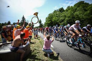 Los espectadores animan desde una piscina inflable instalada a lo largo de la carretera mientras el grupo de ciclistas pasa en bicicleta durante la séptima etapa de la 110ª edición de la carrera ciclista del Tour de Francia, 170 km entre Mont-de-Marsan y Burdeos, en el suroeste de Francia, el 7 de julio de 2023. (Foto de Anne-Christine POUJOULAT / AFP)
