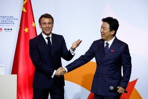 French President Emmanuel Macron shakes hands with Chinese actor Huang Bo following a speech to inaugurate the Festival Croisements at the Red Brick Museum in Beijing, China, April 5, 2023. REUTERS/Gonzalo Fuentes
