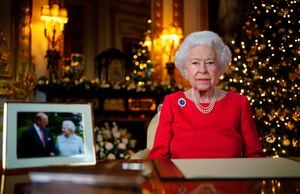 Una imagen publicada el 23 de diciembre de 2021 muestra a la reina Isabel II de Gran Bretaña posando para una fotografía mientras grababa su mensaje anual del día de Navidad, con una fotografía de ella y de su difunto esposo, el príncipe Felipe de Gran Bretaña, duque de Edimburgo, tomada en 2007 en Broadlands, para marcan su aniversario de bodas de diamantes, en el White Drawing Room del Castillo de Windsor, al oeste de Londres. (Photo by Victoria Jones / POOL / AFP) / EMBARGOED UNTIL 2230 GMT on December 23, 2021.