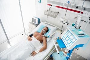 Retrato de vista superior de caballero de mediana edad en ventilador mecánico durmiendo en la sala de recuperación después de la cirugía. El hombre está acostado con goteo intravenoso en su brazo y oxímetro de pulso en el dedo