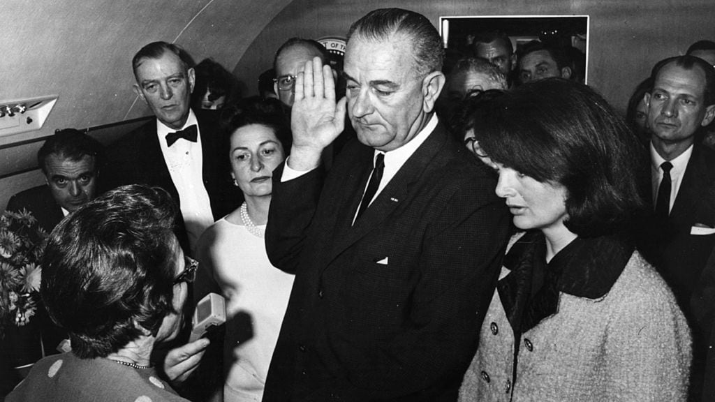 Jackie asistió al juramento del nuevo presidente, Lyndon B. Johnson con la prenda todavía puesta.