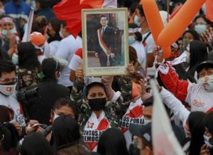 A Peruvian right-wing presidential candidate Keiko Fujimori supporter holds a portrait of her father and former Peruvian President Alberto Fujimori during her campaign closing rally in Lima, on June 3, 2021, ahead of the June 6 runoff election against leftist candidate Pedro Castillo. (Photo by Juan PONCE / AFP)