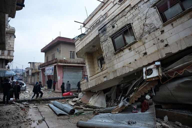 Los residentes caminan a lo largo de un edificio derrumbado luego de un terremoto en la ciudad de Jandaris, en el campo de la ciudad de Afrin, en el noroeste de Siria, en la parte rebelde de la provincia de Alepo, el 6 de febrero de 2023. un terremoto de magnitud 7,8 que se originó en Turquía y se sintió en los países vecinos.