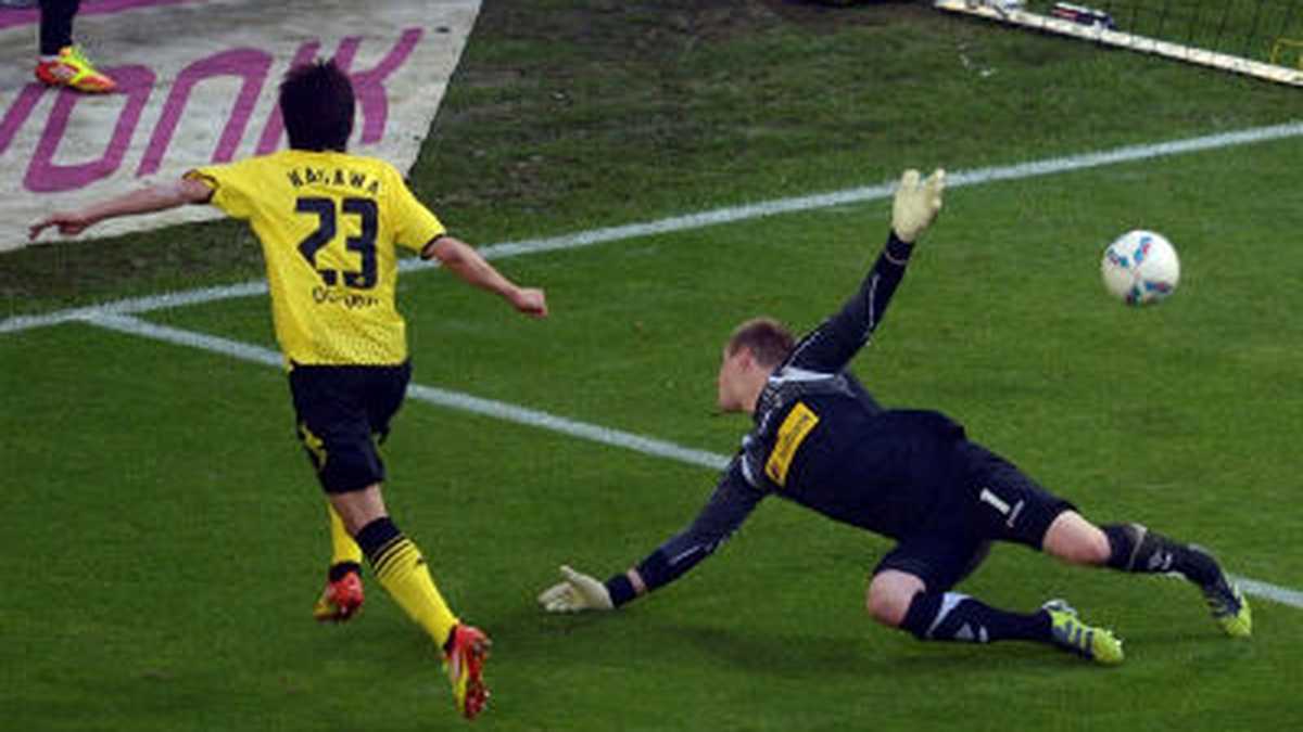 El jugador de Borussia Dortmund Shinji Kagawa (i) marca el segundo gol de su equipo durante el partido de fútbol de la Bundesliga alemana ante el Borussia Mönchengladbach, disputado en el estadio Signal Iduna Park en Dortmund, Alemania.