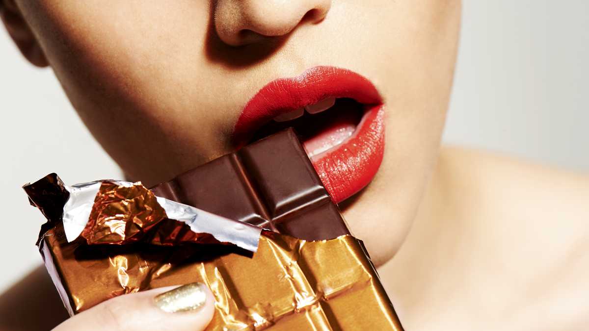 Foto de referencia de una mujer comiendo chocolate