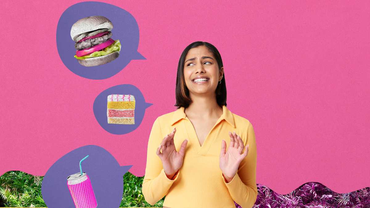 young woman making face at junk food against pink background