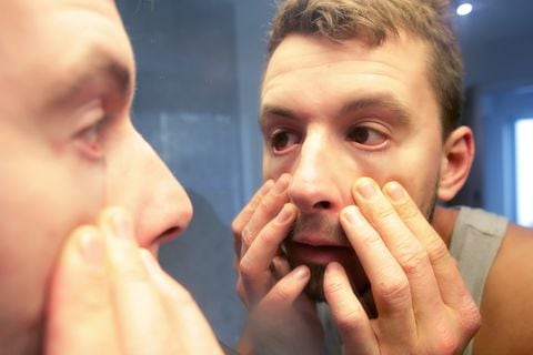 Hombre mirándose a los ojos en el espejo - Foto de referencia