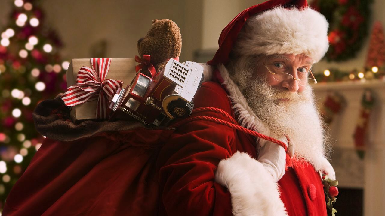 Santa Claus llevando una bolsa con regalos.