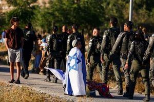 Un niño israelí se encuentra junto a los agentes de la Policía Fronteriza durante una reunión del movimiento de asentamientos israelíes que intenta establecer un nuevo asentamiento cerca de Kiryat Arba, un asentamiento judío en Hebrón, en la Cisjordania ocupada por Israel, el 20 de julio de 2022. Foto REUTERS/Ronen Zvulun