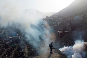 Un trabajador de la salud rocía vapor de fumigación para detener la propagación del virus del dengue en el cementerio Nueva Esperanza en Lima, Perú, el 1 de junio de 2022. Fotografía tomada con un dron. Foto REUTERS/Sebastián Castañeda 