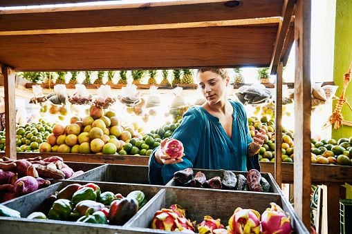 Mujer está en un supermercado escogiendo alimentos orgánicos