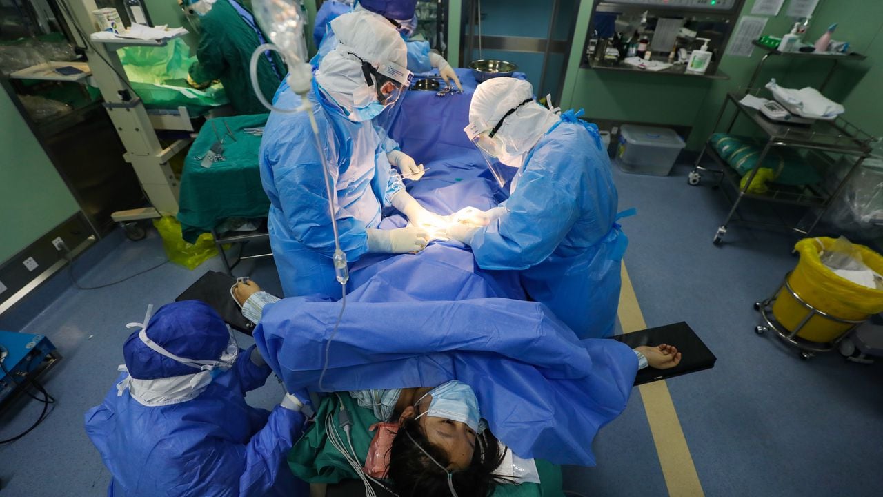 Trabajadores médicos realizan la operación de cesárea en una paciente sospechosa de COVID-19