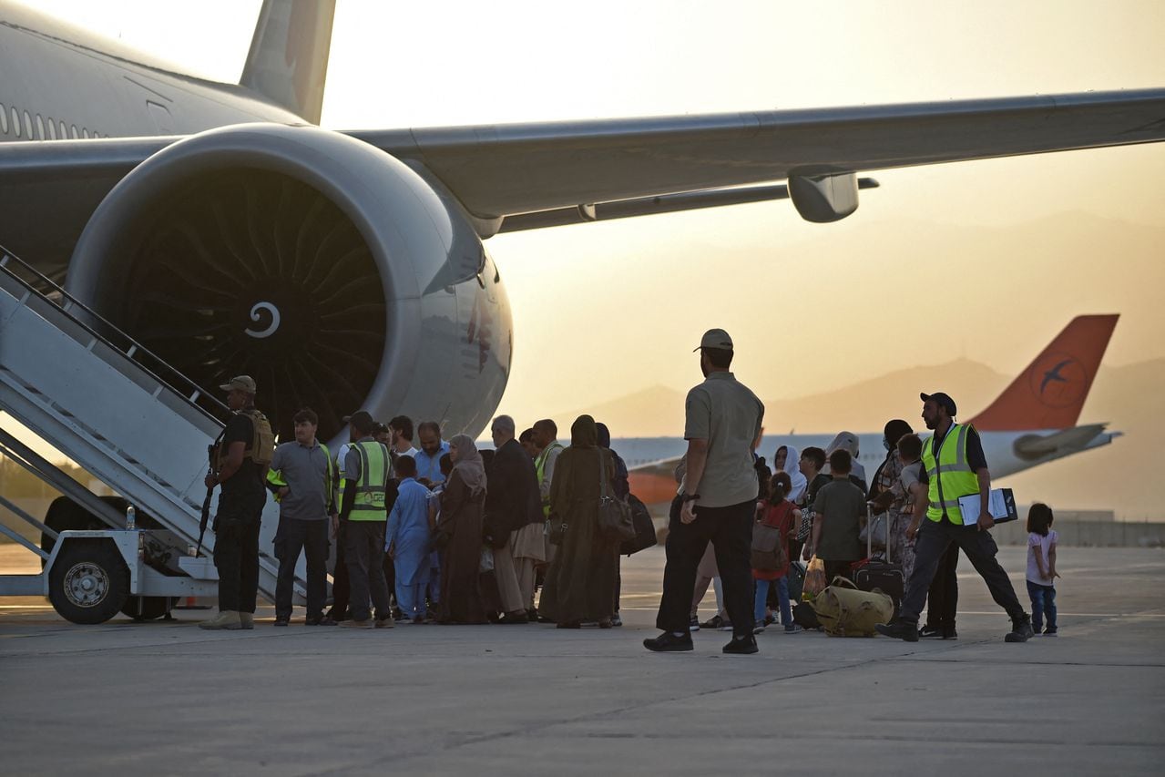 Los pasajeros se preparan para abordar un avión de Qatar Airways en el aeropuerto de Kabul el 9 de septiembre de 2021. - Unos 200 pasajeros, incluidos ciudadanos estadounidenses, salieron del aeropuerto de Kabul el 9 de septiembre de 2021, en el primer vuelo con extranjeros fuera de la capital afgana desde un La evacuación liderada por Estados Unidos terminó el 30 de agosto (Foto de WAKIL KOHSAR / AFP)