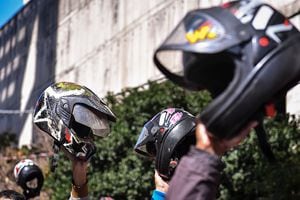 BELO HORIZONTE, BRAZIL - JULY 01: Delivery app workers raise their motorcycle helmets in front of the department of labor as they take part in a protest to demand better working conditions on July 1, 2020 in Belo Horizonte, Brazil. The demonstration takes place in several states in Brazil, and it is an attempt to draw attention to the lack of formal employment between applications and couriers. During the stoppage, delivery workers asked users of delivery services not to place any orders today in support of the movement.    (Photo by Pedro Vilela/Getty Images)