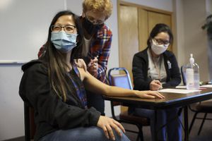 Lisa Xiong, miembro del personal de The Hmong Institute, recibe su primera dosis de la vacuna Moderna en una clínica del Life Center en Madison, Wisconsin. (Coburn Dukehart / Wisconsin Watch vía AP)