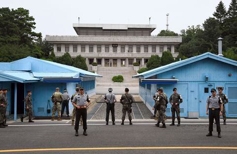 Soldados de Corea del Sur y Estados Unidos montan guardia durante una ceremonia conmemorativa del 64 aniversario de la firma del Acuerdo de Armisticio de la Guerra de Corea en la aldea de tregua de Panmunjom en la Zona Desmilitarizada (DMZ) que divide las dos Coreas