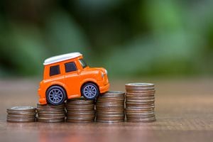 Carro y monedas sobre el precio que vale un seguro
