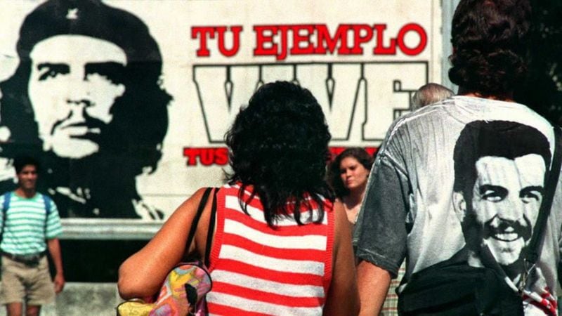 Una pareja camina delante de un mural dedicado al Che Guevara en La Habana.