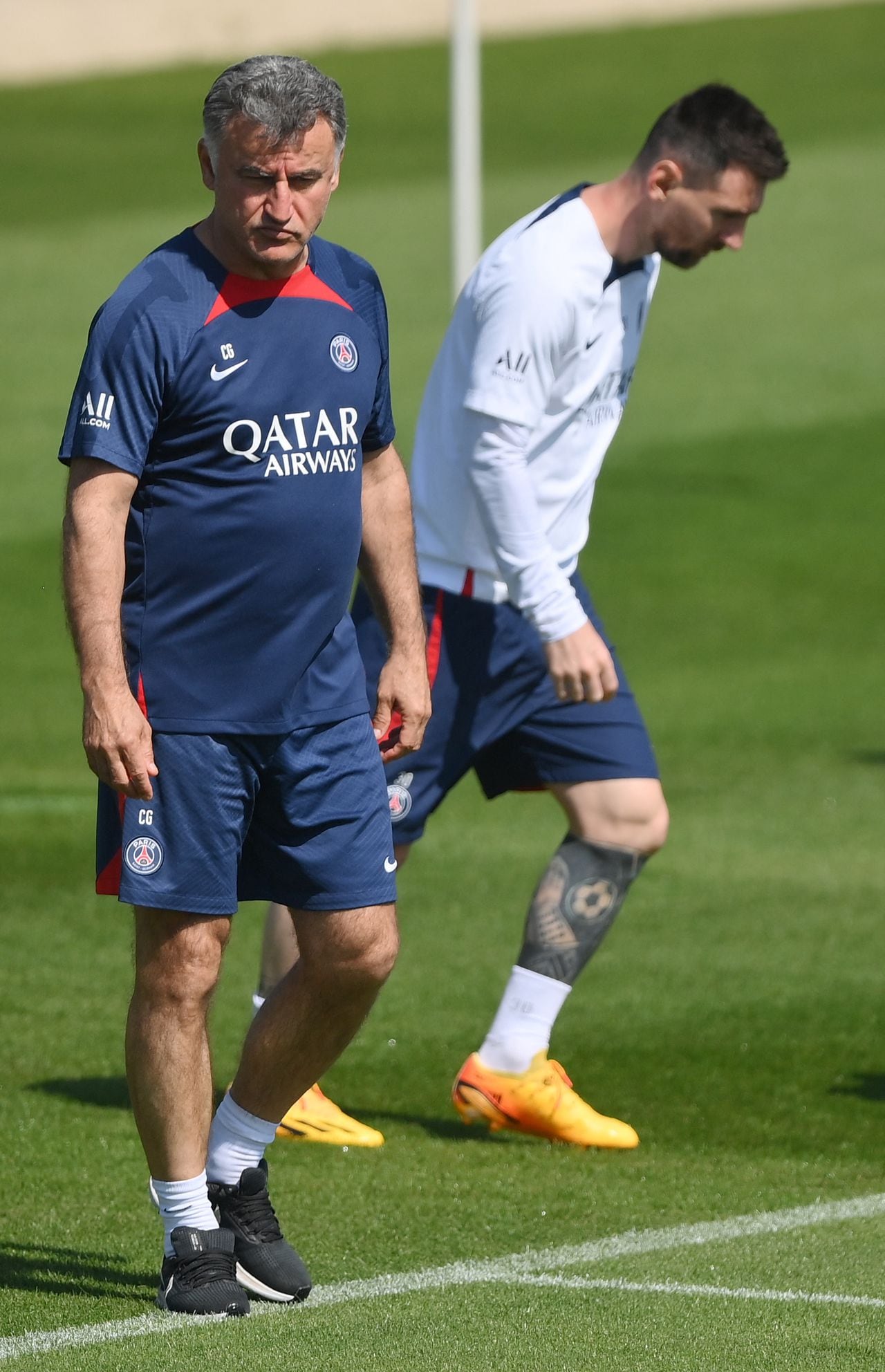 Paris Saint-Germain's French head coach Christophe Galtier (L) walks on the pitch next to Paris Saint-Germain's Argentine forward Lionel Messi during a training session at club's training ground in Saint-Germain-en-Laye, west of Paris on June 1, 2023, two days prior to the L1 football match against Clermont. (Photo by FRANCK FIFE / AFP)