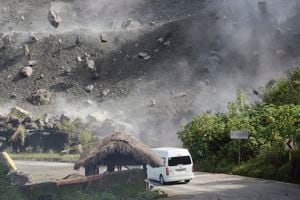 Los piedras caen cuando un vehículo transita por la carretera durante un terremoto en Bauko, Provincia de la Montaña, Filipinas el miércoles 27 de julio de 2022. Foto AP/Harley Palangchao