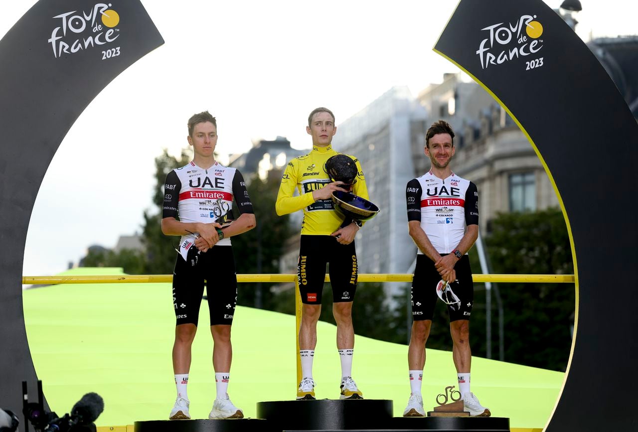 PARIS, FRANCE - JULY 23: Second place Tadej Pogacar of Slovenia and UAE Team Emirates, Tour de France 2023 winner, yellow jersey Jonas Vingegaard of Denmark and Jumbo - Visma, third place Adam Yates of Great Britain and UAE Team Emirates celebrate during the podium ceremony following stage twenty-one, last and final stage of the 110th Tour de France 2023, a 115km stage from Saint-Quentin-en-Yvelines to Paris Champs-Elysees / #UCIWT / on July 23, 2023 in Paris, France. (Photo by Jean Catuffe/Getty Images)