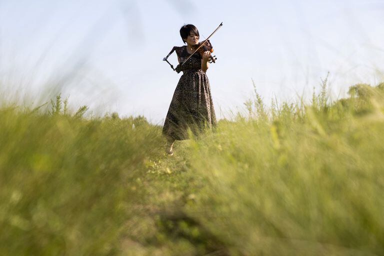 In this photo taken on August 28, 2021, Japanese musician Manami Ito, who is also a qualified nurse and former Paralympic swimmer, plays the violin using her prosthetic arm during a photography session in Shizuoka. - The Japanese musician enthralled a nation with her brief but showstealing performance at the opening ceremony of the Tokyo Paralympics, and playing violin isn't even her day job. (Photo by Yuki IWAMURA / AFP) / TO GO WITH PARALYMPICS-2020-2021-JAPAN-MUSIC-DISABLED,INTERVIEW BY ETIENNE PALMER AND HARUMI OZAWA