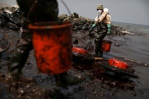 Trabajadores limpian un derrame de petróleo luego de una erupción volcánica submarina en Tonga, en Ancón, Perú 25 de enero de 2022. Foto REUTERS/Pilar Olivares
