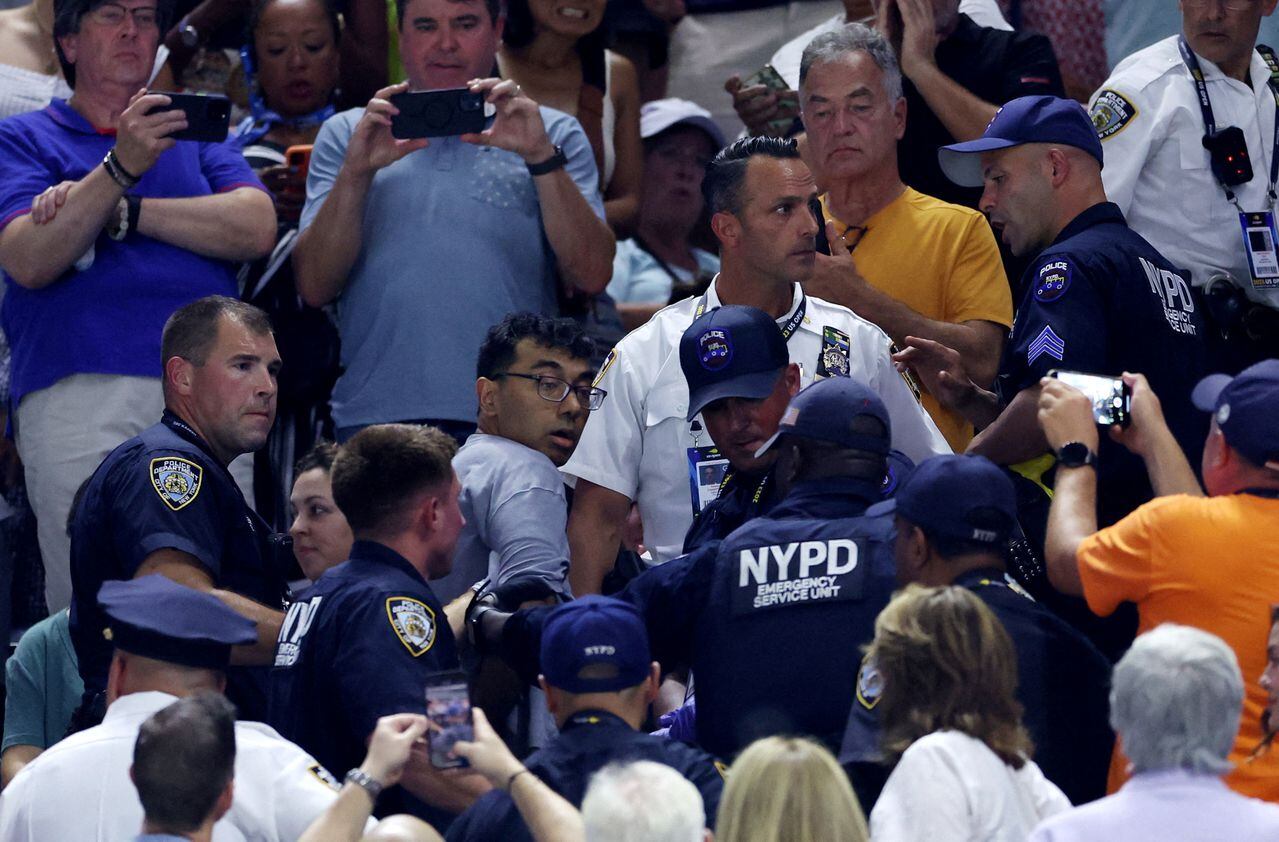 Oficiales del Departamento de Policía de la Ciudad de Nueva York (NYPD) están sacando a un manifestante del estadio durante el partido semifinal entre Karolina Muchova de la República Checa y Coco Gauff de EE.UU.