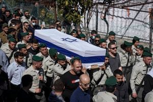 Israeli border police officers carry the flag-draped coffin of Druze Israeli border police officer Yezen Falah, 19, during his funeral in the village of Kisra-Sumei, northern Israel, Monday, March 28, 2022. Falah was killed in a Sunday night shooting attack by a pair of Arab gunmen, in the central Israeli city of Hadera that police say killed two people and wounded four. The militant Islamic State group has claimed responsibility for the attack and the shooters were killed by police. (AP Photo/Ariel Schalit)