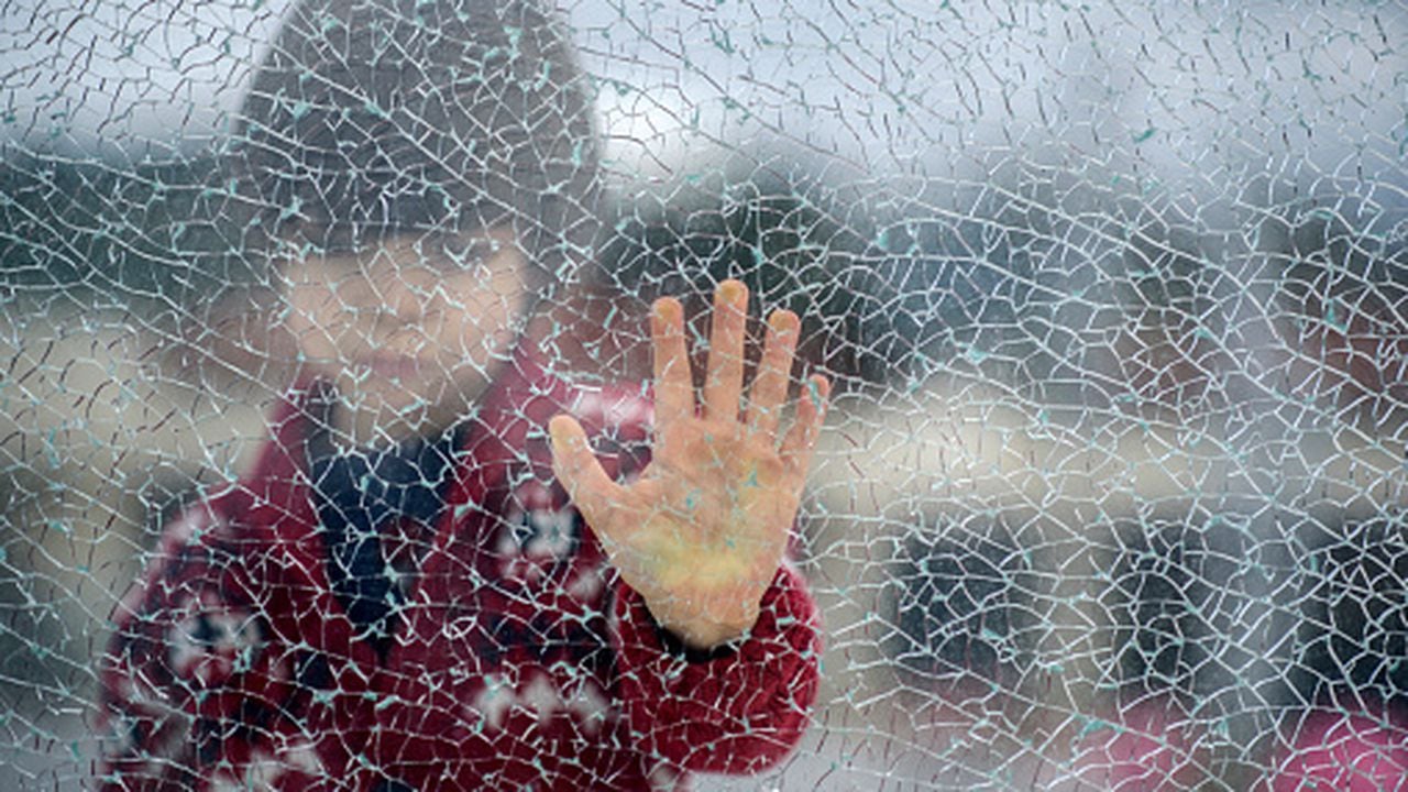 Niño detrás de un vidrio roto, parece ser que lo abandonaron sus padres.