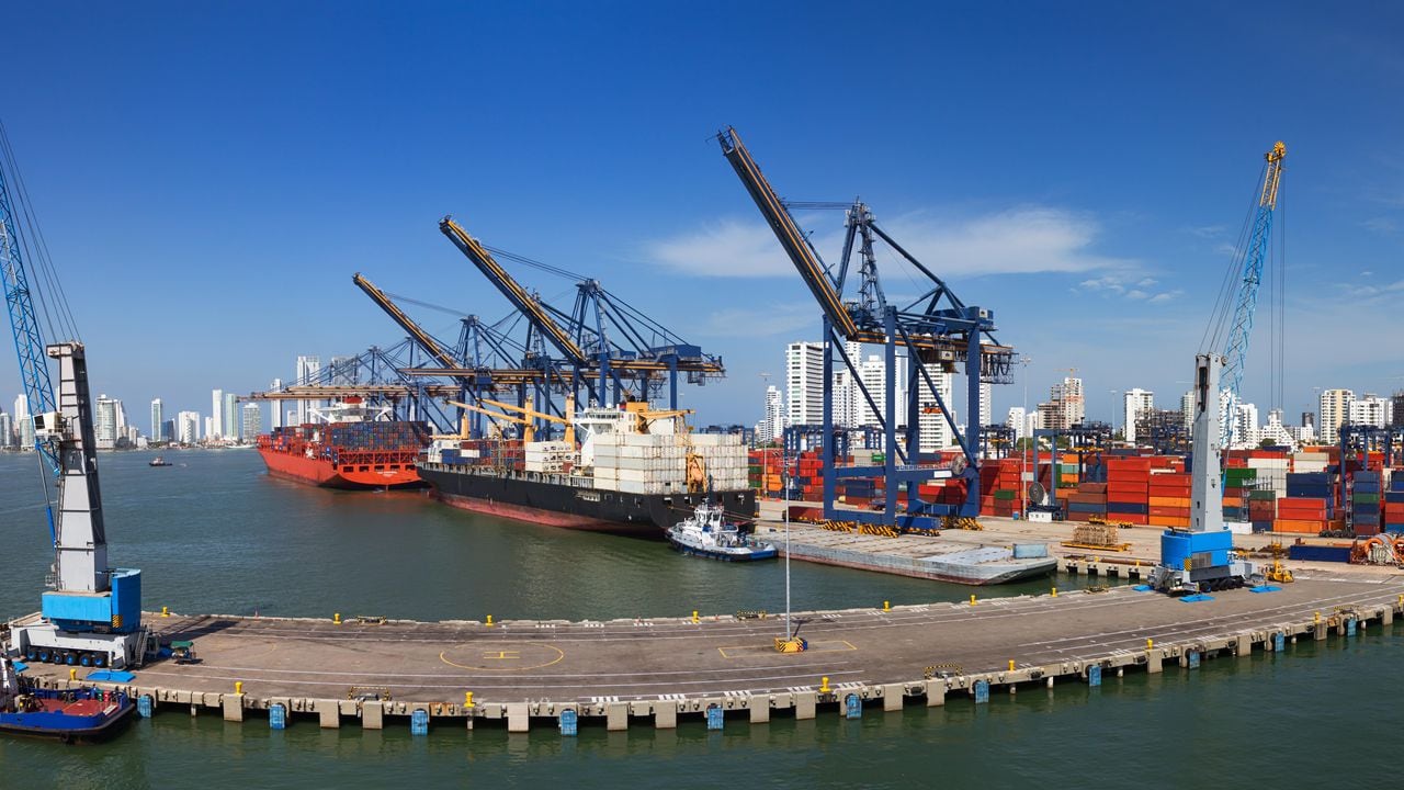 Vista panorámica de una actividad portuaria con cargueros, grúas y contenedores en el muelle del Puerto de Cartagena, Colombia.
