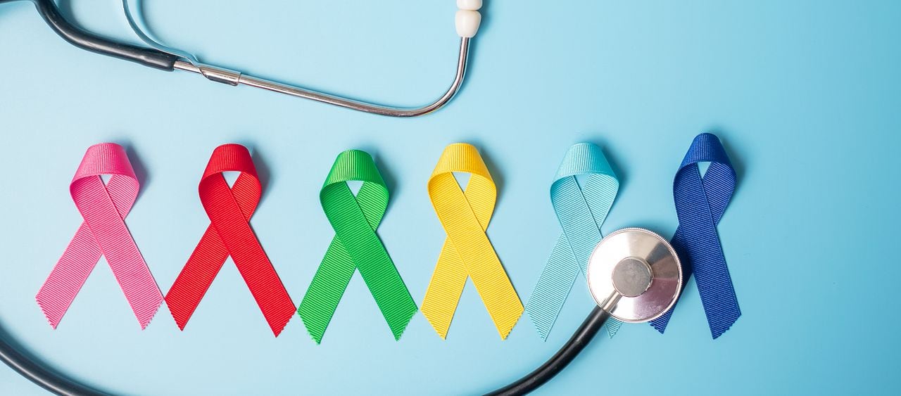 Día mundial del cáncer (4 de febrero). cintas de colores de conciencia; color azul, rojo, verde, rosa y amarillo sobre fondo de madera para apoyar a las personas que viven y enferman. Concepto de salud y medicina
