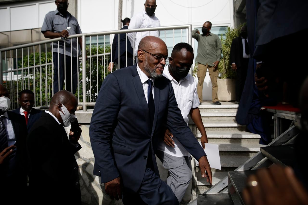 El nuevo primer ministro de Haití, Ariel Henry, sube escaleras acompañado de escoltas después de ser designado al cargo, el martes 20 de julio de 2021, en Puerto Príncipe. (AP Foto/Joseph Odelyn)