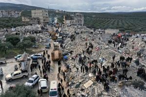 Los trabajadores de defensa civil y los residentes buscan entre los escombros de los edificios derrumbados en la ciudad de Harem, cerca de la frontera turca, provincia de Idlib, Siria, el lunes 6 de febrero de 2023.