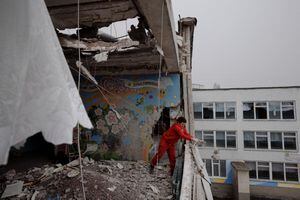 Una mujer limpia los escombros de una escuela dañada por los bombardeos en Kharkiv mientras continúa el ataque de Rusia contra Ucrania, Ucrania, 27 de marzo de 2022. Foto REUTERS/Thomas Peter