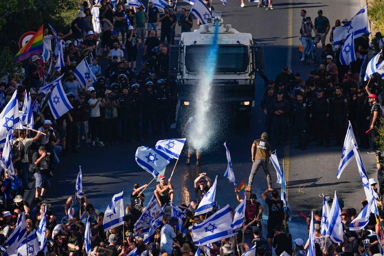 La policía israelí utiliza un cañón de agua para dispersar a los manifestantes que bloquean una carretera durante una protesta contra los planes del gobierno del primer ministro Benjamin Netanyahu para reformar el sistema judicial, en Jerusalén, el lunes 24 de julio de 2023.