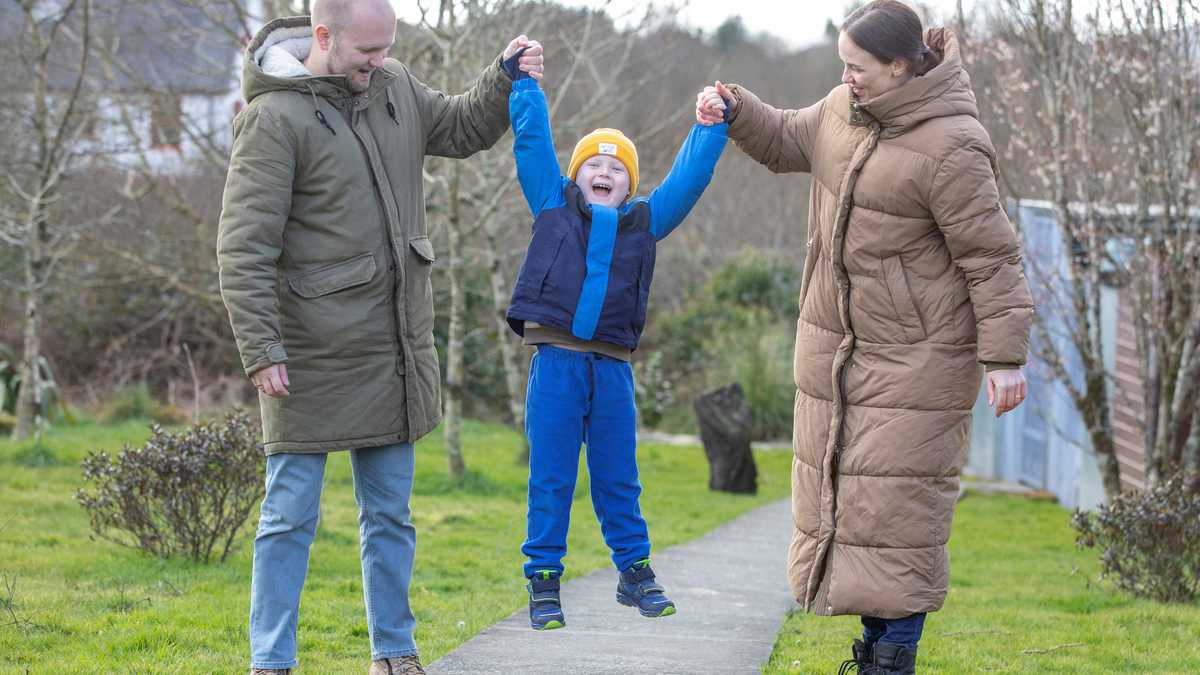 Yana (R) and Serhiy Shapoval (L) play with their five-year-old son Leonid, who suffers from leukaemia, in their new home in Ballydehob, near Cork, south west Ireland, on March 7, 2022 after fleeing Ukraine following Russia's invasion of the country. - The Shapovals escaped the war in Ukraine after doctors urged the parents of Leonid to leave the country on March 3, 2022, telling them there was no more they could do for their son. Yana and Serhiy have since learnt that the hospital, where Leonid received his chemotherapy in Kyiv, has been bombed by Russian forces. Five-year-old Leonid is now being treated in Ireland for his condition. (Photo by PAUL FAITH / AFP)