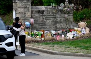 Ivy Huesmann abraza a la oficial de policía de Metro Nashville, Angeline Comilla, antes de visitar el monumento improvisado en la entrada de la Escuela Covenant el martes 28 de marzo de 2023 en Nashville, Tennessee. (Mark Zaleski /The Tennessean via AP)