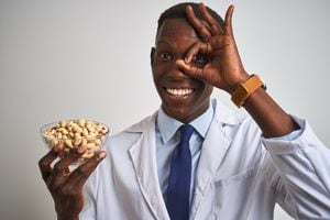 Hombre médico afroamericano sosteniendo un tazón con pistachos. Foto: Getty Images.