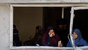 Los palestinos observan el ataque israelí contra una casa, en medio del conflicto en curso entre Israel y el grupo islamista palestino Hamas, en Rafah, en el sur de la Franja de Gaza, el 4 de abril de 2024.