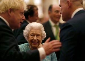 La reina de Inglaterra, Isabel II, y el primer ministro británico, Boris Johnson, a la izquierda, saludan a los asistentes a una recepción en la Cumbre Global de Inversiones en el Castillo de Windsor, Inglaterra, el martes 19 de octubre de 2021. (AP Foto/Alastair Grant, Pool)