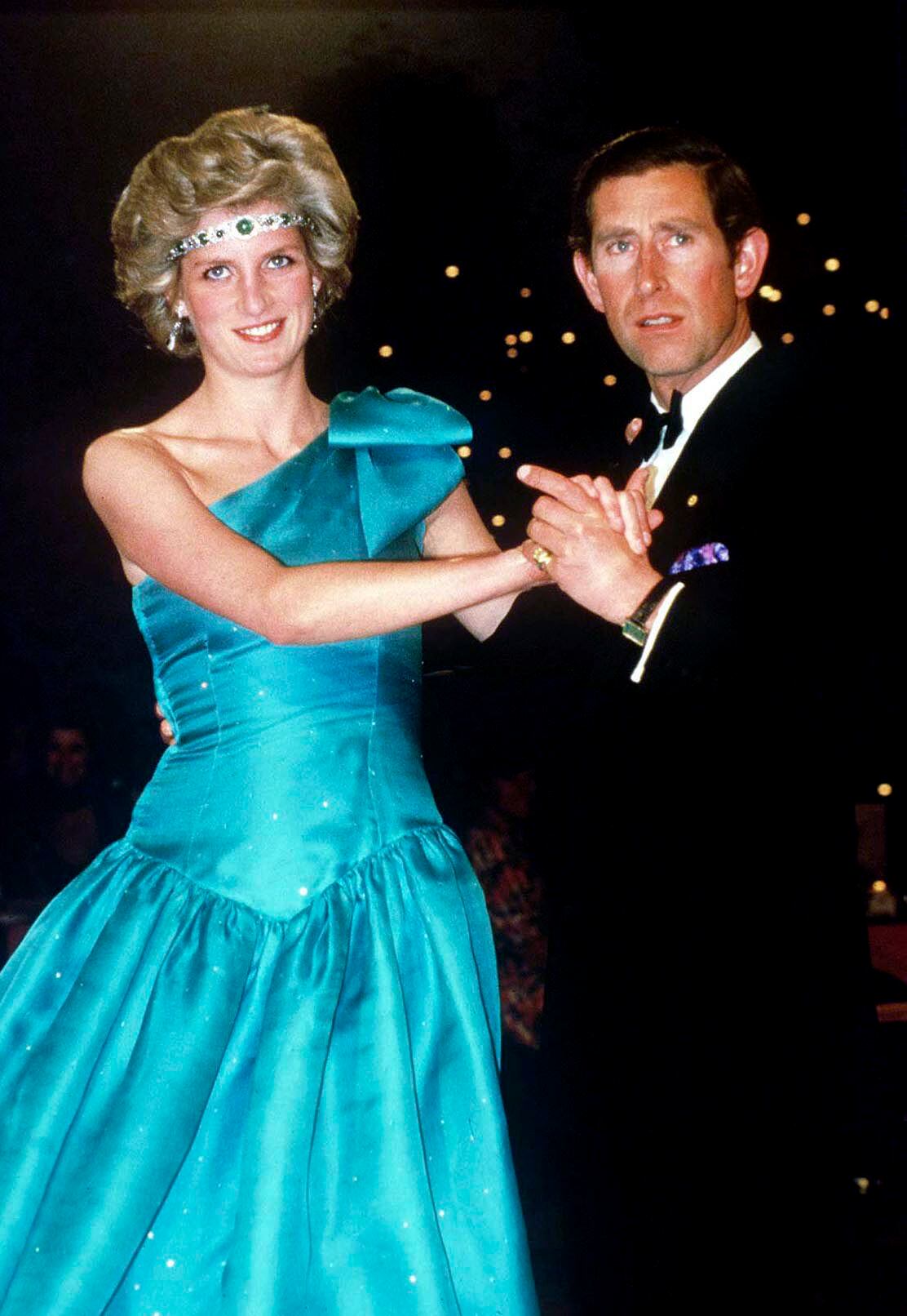 MELBOURNE, AUSTRALIA - OCTOBER 01:  Prince Charles Dancing With His Wife, Princess Diana, In Melbourne, During Their Official Tour Of Australia.  The Princess Is Wearing A Diamond And Emerald Choker (a Wedding Gift From The Queen) As A Headband With A One-shouldered Turquoise Satin Organza Dress Designed By David And Elizabeth Emanuel.  (Photo by Tim Graham Photo Library via Getty Images)