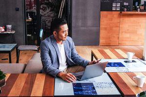 Hombre de negocios asiático trabajando solo sentado en un espacio de coworking