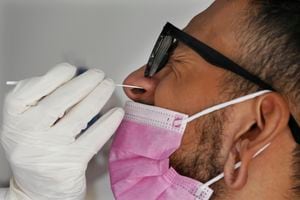 Un trabajador de salud recolecta una muestra de hisopado nasal para una prueba de COVID-19. (Foto AP / Marco Ugarte)