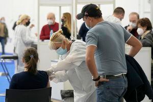 Un hombre mira mientras una mujer rusa recibe la vacuna de Johnson & Johnson para el COVID-19 en Zagreb, Croacia. Pese a un aumento de las infecciones con coronavirus en Croacia, el país se ha vuelto el destino favorito de los rusos que buscan obtener vacunas occidentales, que necesitan para viajar por Europa y a Estados Unidos. (AP Foto/Darko Bandic)