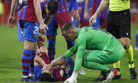 Barcelona's Jordi Alba, bottom, is comforted by teammate goalkeeper Marc-Andre ter Stegen during the Spanish La Liga soccer match between Sevilla and Barcelona at the Ramon Sanchez-Pizjuan stadium, in Seville, Spain, Tuesday, Dec. 21, 2021. The match ended in a 1-1 draw. (AP/Angel Fernandez)